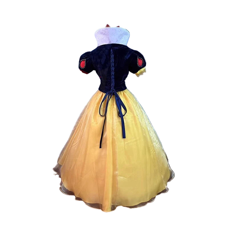 Costume with a yellow dress and dark blue bodice against a blue textured wall.
