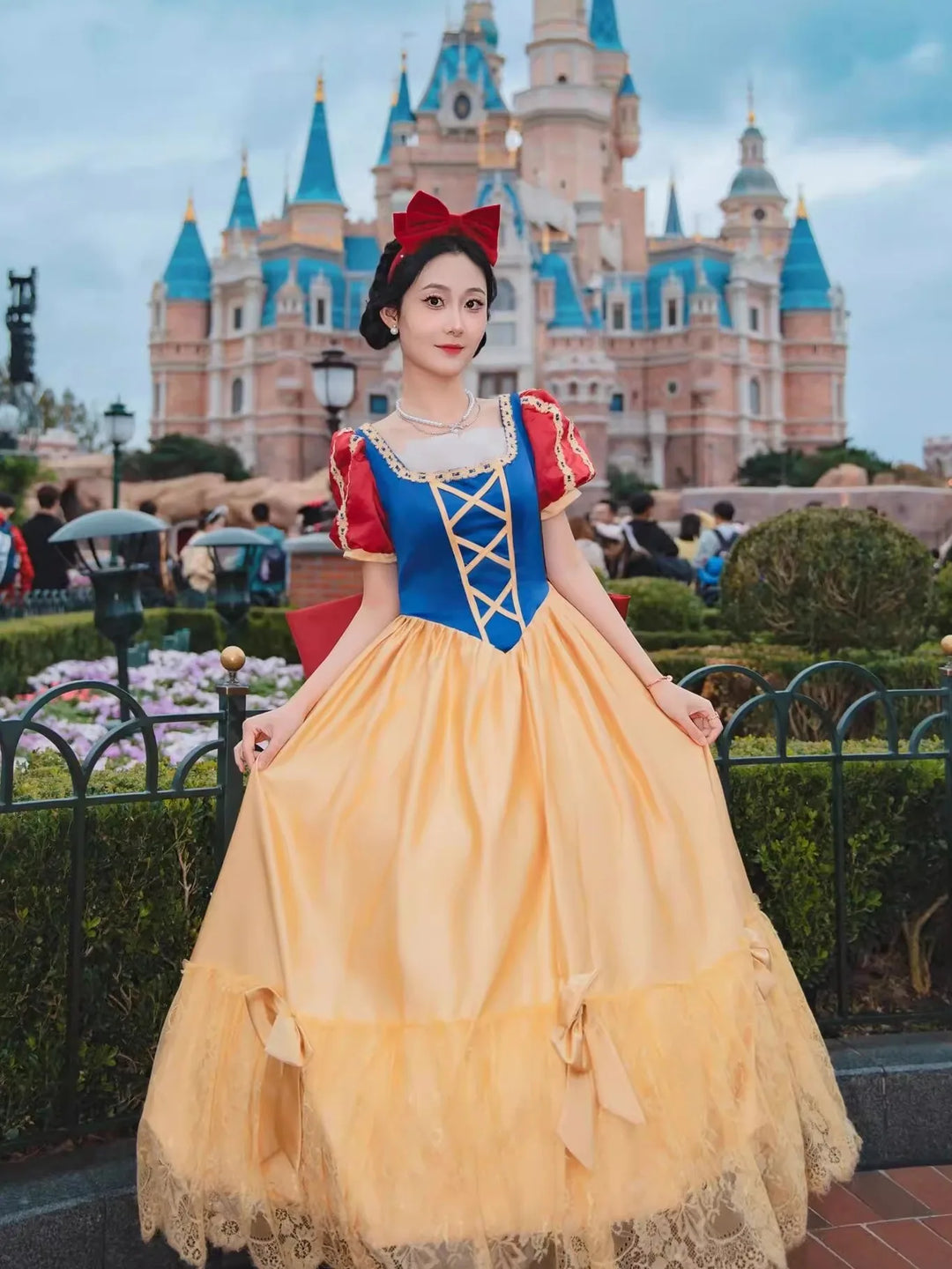 Person in Snow White costume standing in front of a castle-like structure