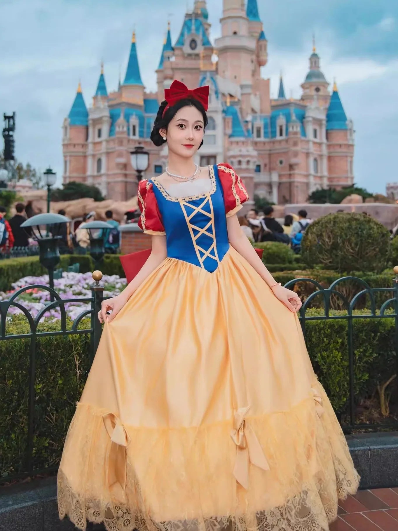 Person in Snow White costume standing in front of a castle-like structure