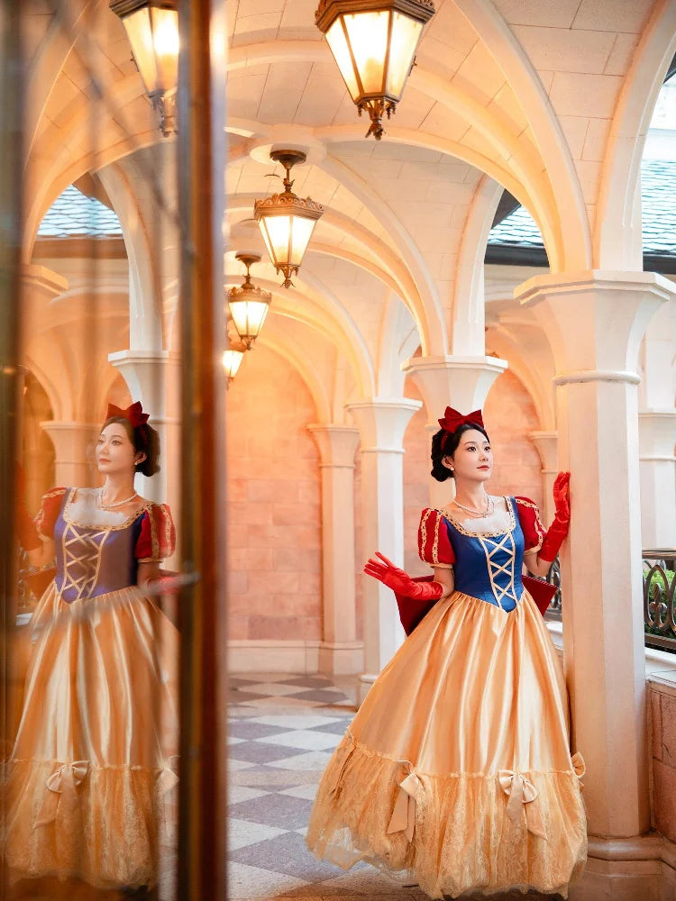 Woman in Snow White costume standing in a decorative hallway with arches and lights.