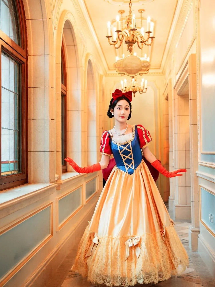 Person in a Snow White costume standing in an elegant hallway with chandeliers.
