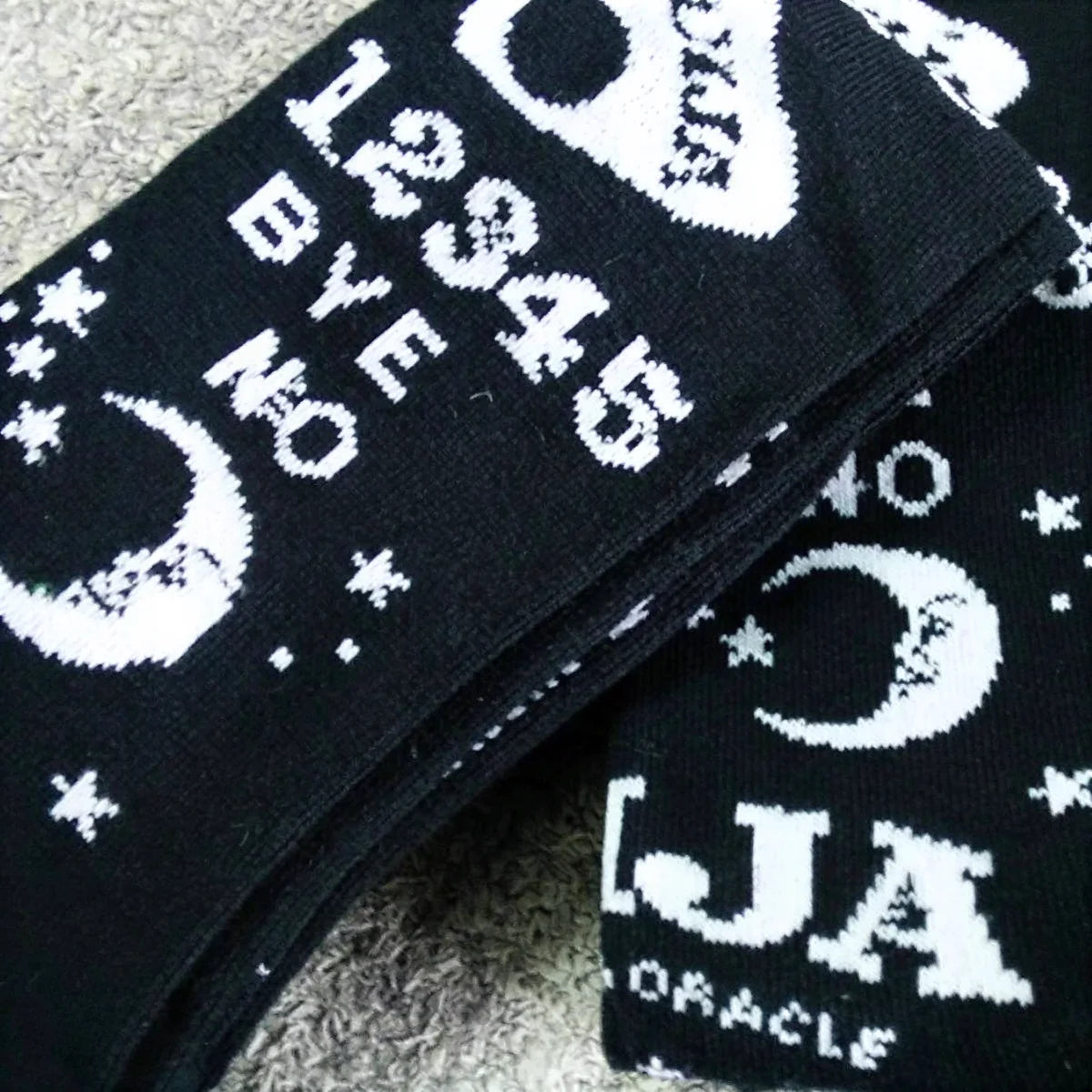 Dark magic stockings in black knit with white Ouija board design and moon motifs.