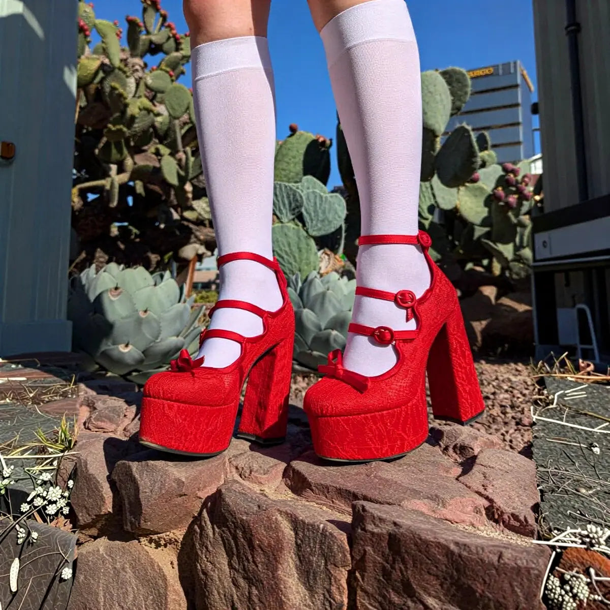 Red platform heels with ankle straps and bow details.