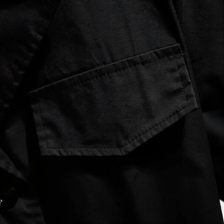 Black dress with textured fabric and flap pocket detail.