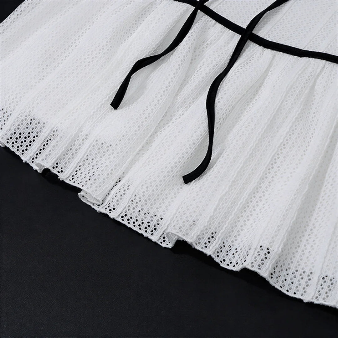White eyelet skirt with black ribbon ties at waist.
