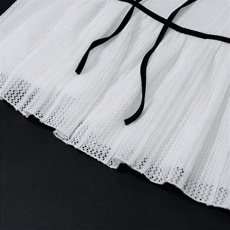 White eyelet skirt with black ribbon ties at waist.