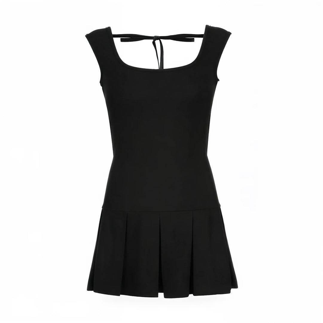 Backless mini dress in black, fitted bodice with pleated skirt and tie-back detail.