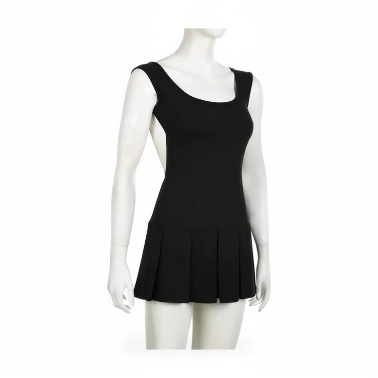 Backless mini dress in black, stretch knit, pleated skirt hem.