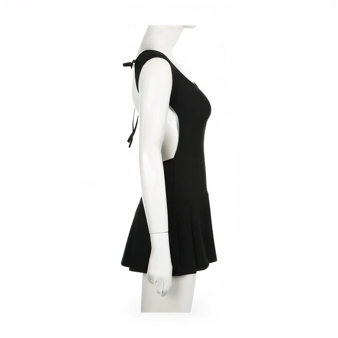 Backless mini dress in black, sleeveless with tie straps and flared skirt.