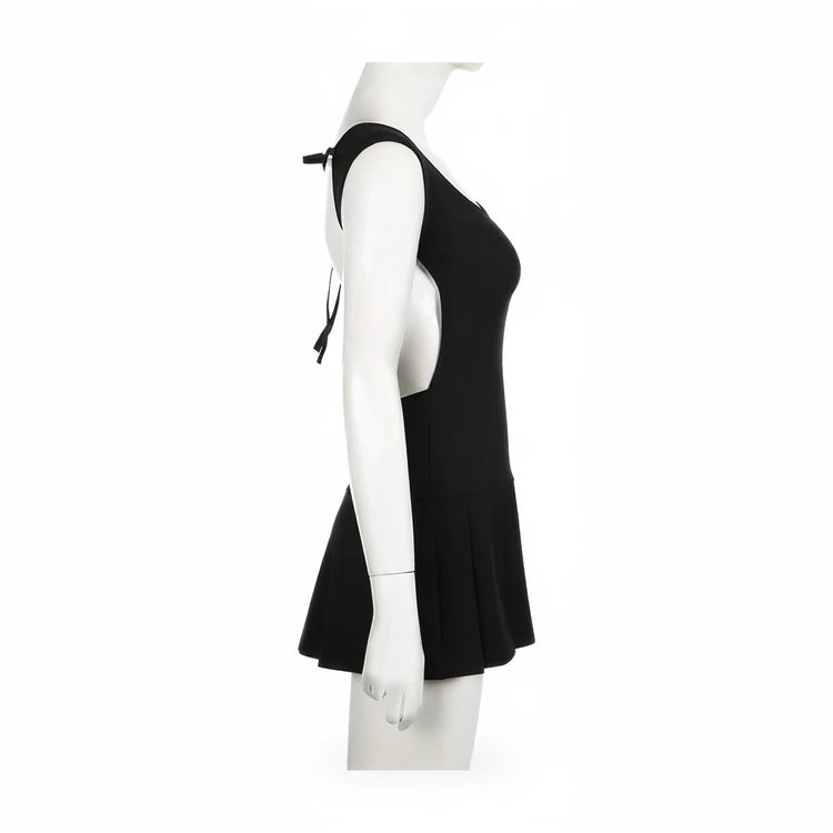 Backless mini dress in black, sleeveless with tie straps and flared skirt.