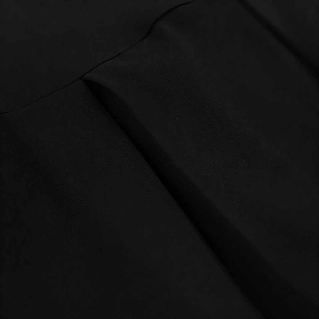Backless mini dress in black, smooth fabric with subtle seam detailing.