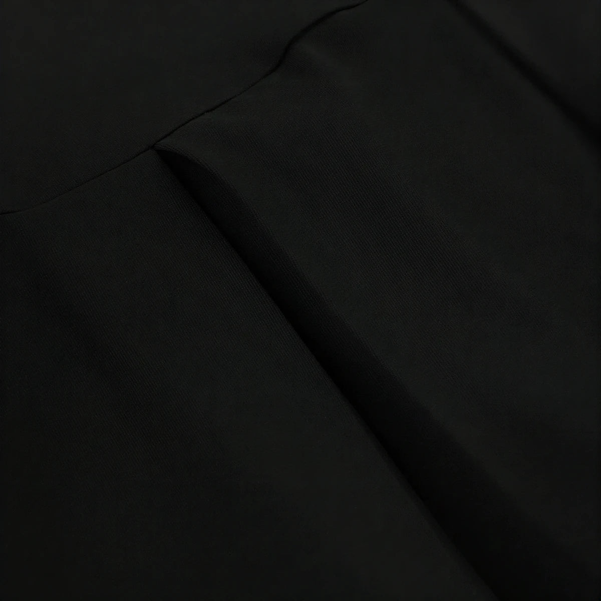 Backless mini dress in black, smooth fabric with subtle seam detailing.