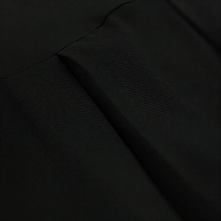 Backless mini dress in black, smooth fabric with subtle seam detailing.