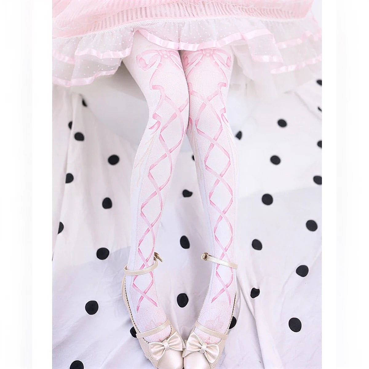 Pink lace-patterned pantyhose with bow detailing at ankles.
