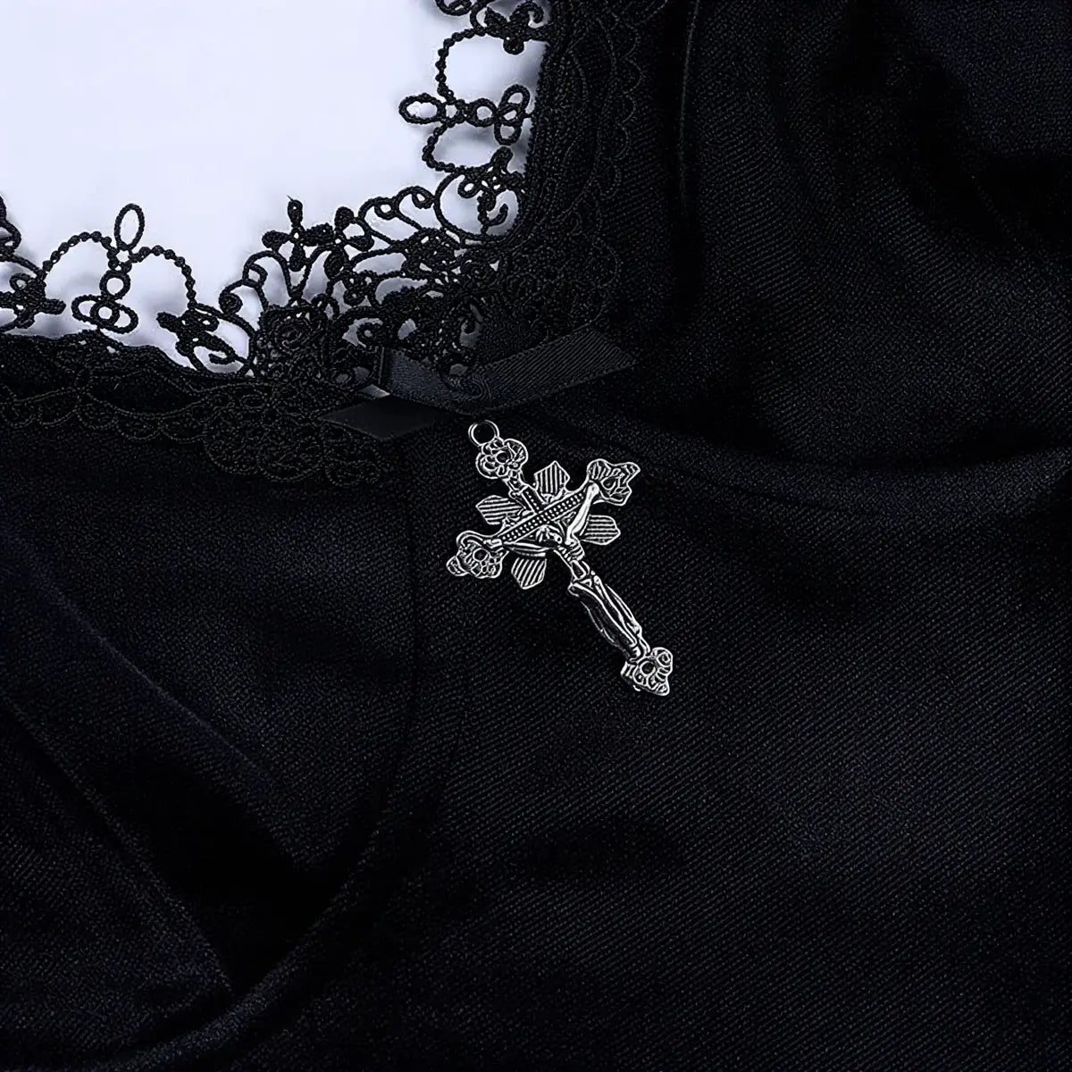 Black velvet dress with lace trim and silver cross pendant.